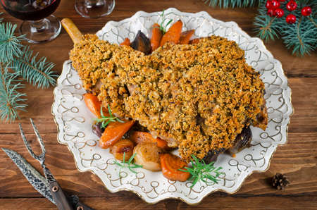Leg of lamb baked with spicy bread crust. Roast leg of lamb with roasted vegetables in the round dishの写真素材