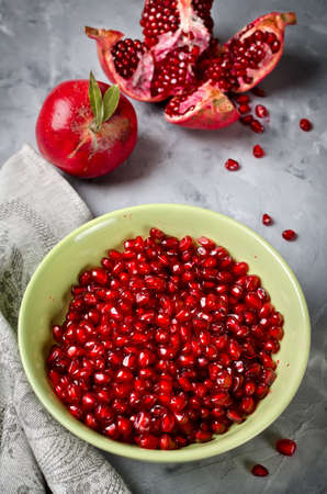 Half pomegranate and seeds pomegranates on gray concrete backgroundの写真素材