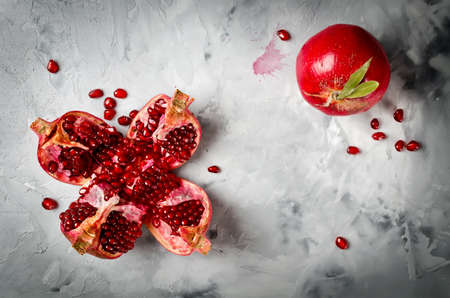 Half pomegranate and seeds pomegranates on gray concrete backgroundの写真素材