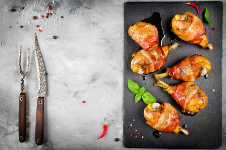 Bacon wrapped chicken legs on a black background. Top viewの写真素材