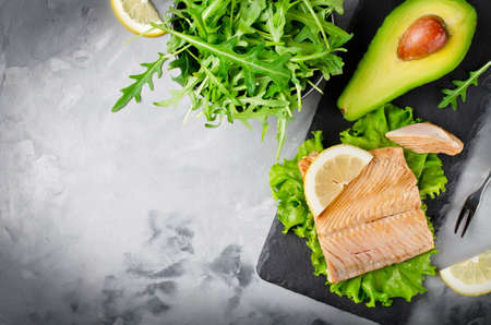 Poached salmon, arugula, lemon, oil, avocado. Gray concrete backgroundの写真素材