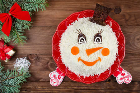 Salad in a shape of a funny snowman. The idea for a delicious and merry holidaysの写真素材