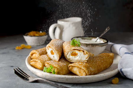 Pancakes stuffed with cottage cheese and raisins. A delicious sweet dessertの写真素材