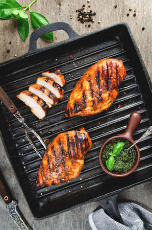 Chicken fillet in the grill pan. Grilled meat with pesto sauceの写真素材