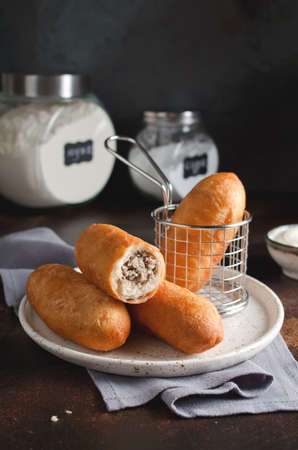 Homemade fried pies with liver and potatoes. Food on a dark background