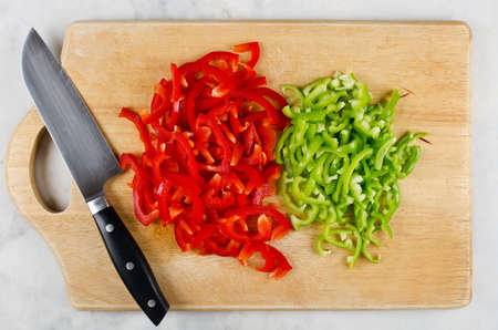 Chopped red and green bell pepper on cutting board. Step by step cooking stir fryの写真素材