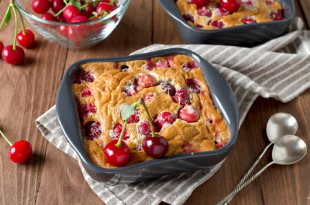 Cherry clafouti in portional ceramic forms on rustic wooden background. Homemade cakeの写真素材