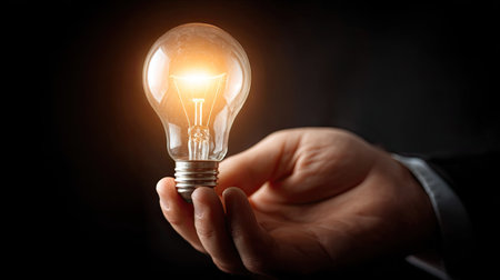 Close up of businessman hand holding light bulb. Idea and innovation conceptの素材