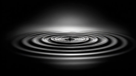 Falling drop of water. Black and white background. Ripples in water.の素材