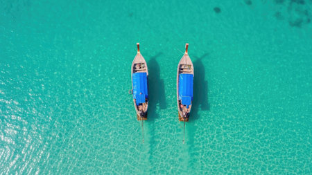 Aerial view of wooden fishing boats moored in the turquoise sea.の素材