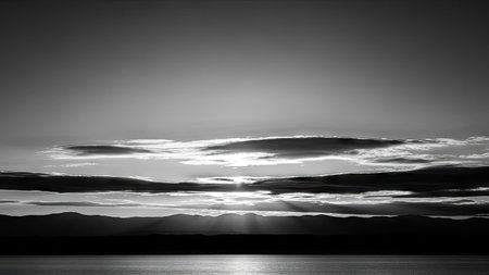 sunset over the lake in black and white with clouds and mountainsの素材