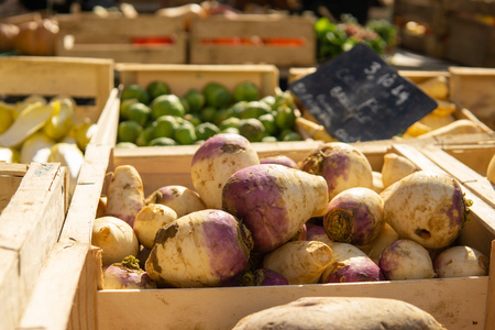 Vegetables out for sale at farmers market in the sun, swedes greens root vegetablesの写真素材