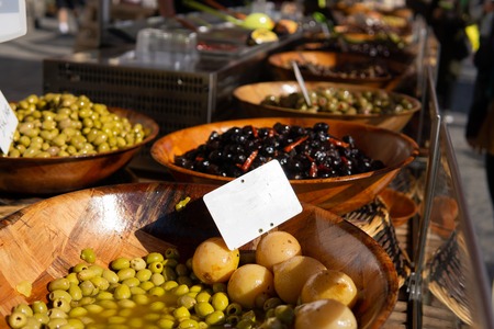 Olives and other pickled vegetables for sale at a sunny farmers marketの写真素材