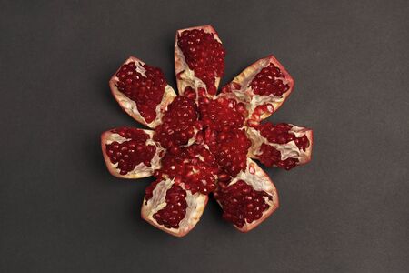Peeled pomegranate fruit on a black background.の写真素材