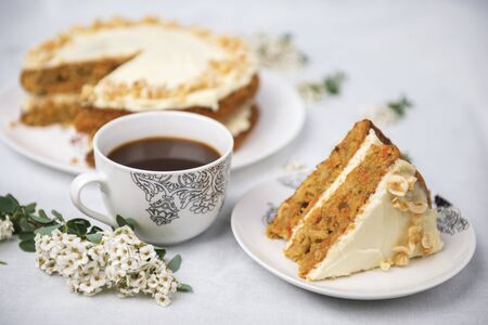 Piece of carrot cake with carrot cake on a white tableclothの写真素材