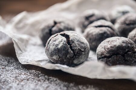 A few marble brown cookies close-up with powdered sugar on parchment backdropの写真素材