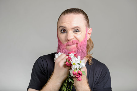 Man with long styled hair and pink beard with flowers on the white background