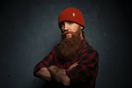 Red bearded man with orange hat and plaid shirt on the cyan backgroundの写真素材