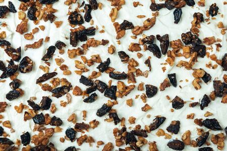 Prune and nut filler spread on white whipped sweat cream. The process of making meringue roll.の写真素材