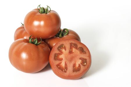 Group of red fresh tomatoes with sliced one on a white backgroundの写真素材