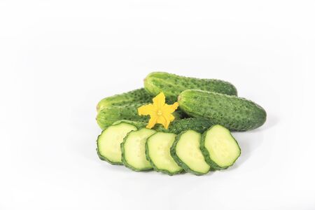 Group of fresh green pickling cucumbers with slices and yellow flower isolated on white backgroundの写真素材