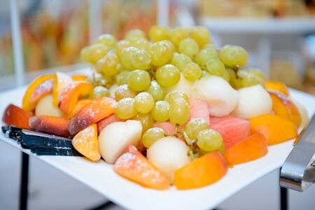 Plate with grape, sliced peaches, watermelons and melons の写真素材