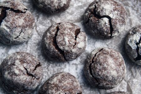 A few marble brown cookies close-up with powdered sugar on parchment backdropの写真素材