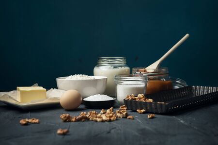 Ingredients and baking utensils for cooking tart, cookies, pastry on dark background. Egg, flour, butter, rolling pin, salt, sugar, milk.の写真素材