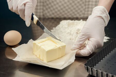 Cook cut a butter for small pieces. Cooking process of tart, cookies or bakery.の写真素材