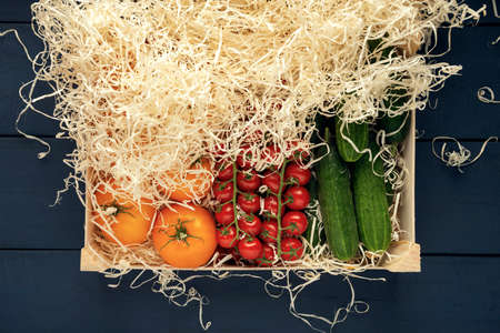 Red wet cherry tomatoes and yellow tomato fruits in black plate on a dark textured background. Top view. Flat lay. Space for text.の写真素材
