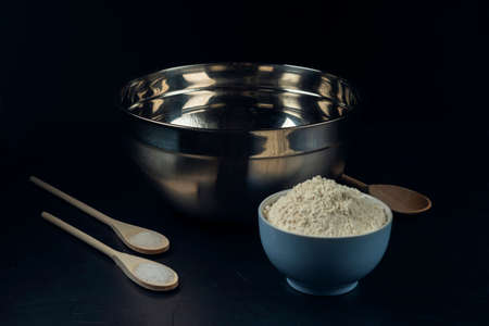 Bowl with flour, sugar, salt, wooden spoon, stainless steel bowl â preparation for making pie, pizza, baking. The process of cooking Adjaruli Khachapuri. The Adjarian Khachapuri Recipe â Georgian cheese bread.の写真素材