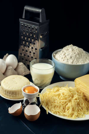 Wheat flour, few types of cheese, milk, eggs, grater â preparation for making pie, pizza, baking. The process of cooking Adjaruli Khachapuri. Adjarian Khachapuri Recipe â Georgian cheese bread.の写真素材