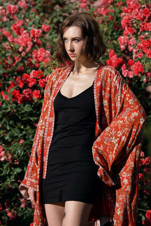 Young pretty female fashion model posing in the rose garden.の写真素材