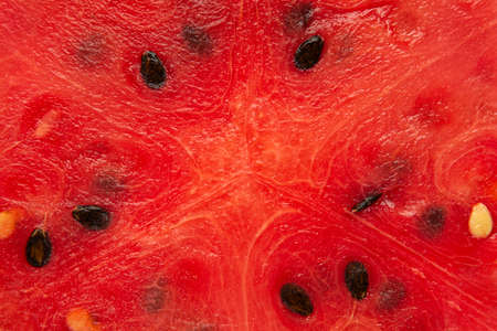 Close-up red flash of cut across watermelon with seeds. Texture. Top view.の写真素材