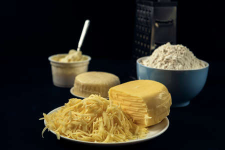Blue bowl with floor, few types of cheese, grater â preparation for making pie, pizza, baking. The process of cooking Adjaruli Khachapuri. Adjarian Khachapuri Recipe â Georgian cheese bread.の写真素材
