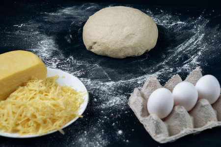 A piece of yeast dough with cheese and eggs. Process of making bakery. The Adjarian Khachapuri Recipe â Georgian cheese bread.の写真素材
