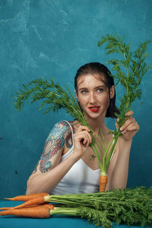 Portrait of dreaming female fashion model hiding behind the carrot leaves.の写真素材