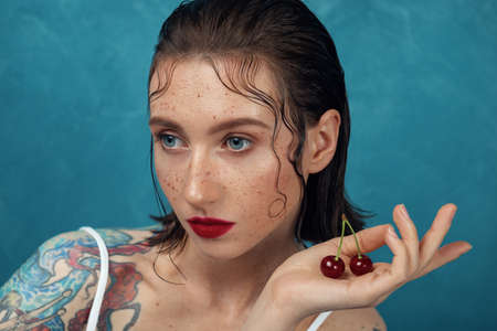 Close-up portrait of young fashion model with the cherry berries.の写真素材
