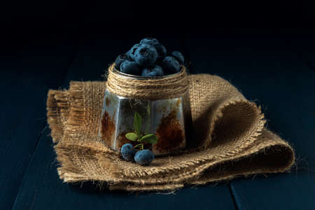 Bowl with ripe blueberry on burlap and the dark wooden tableの写真素材