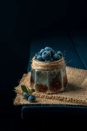 Bowl with wet ripe blueberry on the burlap napkin and dark wooden table. Copy space.の写真素材