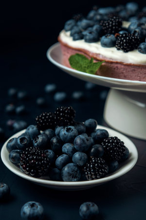 Plate with blackberry and blueberry, cottage cheese casserole on the dark textured background.