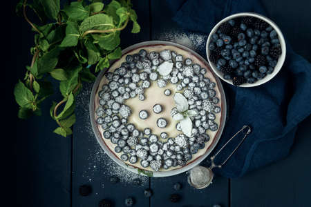 Cottage cheese casserole with blackberry and blueberry sprinkled with icing sugar. Flat lay.の写真素材