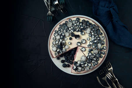 Sliced cottage cheese casserole and cutlery on the dark textured background. Flat lay. Copy space.の写真素材