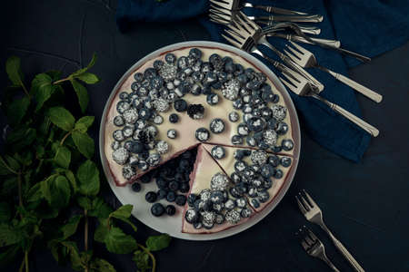 Sliced cottage cheese casserole, mint leaves and cutlery on the dark textured background. Flat lay.の写真素材