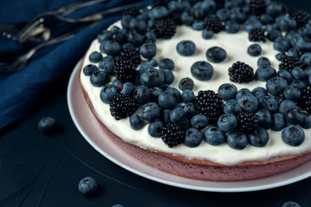 Cottage cheese pie with blackberry and blueberry on the dark textured background.の写真素材