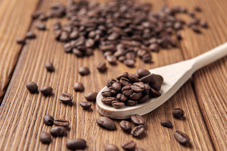 Cup of coffee with coffee beans on the wooden textured table.の写真素材