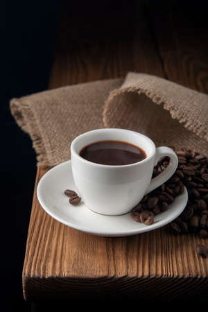 White cup with espresso and coffee beans on the wooden tableの写真素材