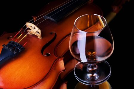 Snifter glass of cognac and violinの写真素材