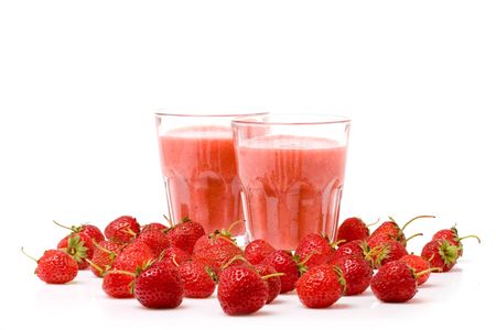 A glass of strawberry smoothie surrounded by fresh berriesの写真素材