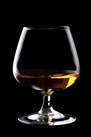 Snifter glass of cognac on black background.の写真素材